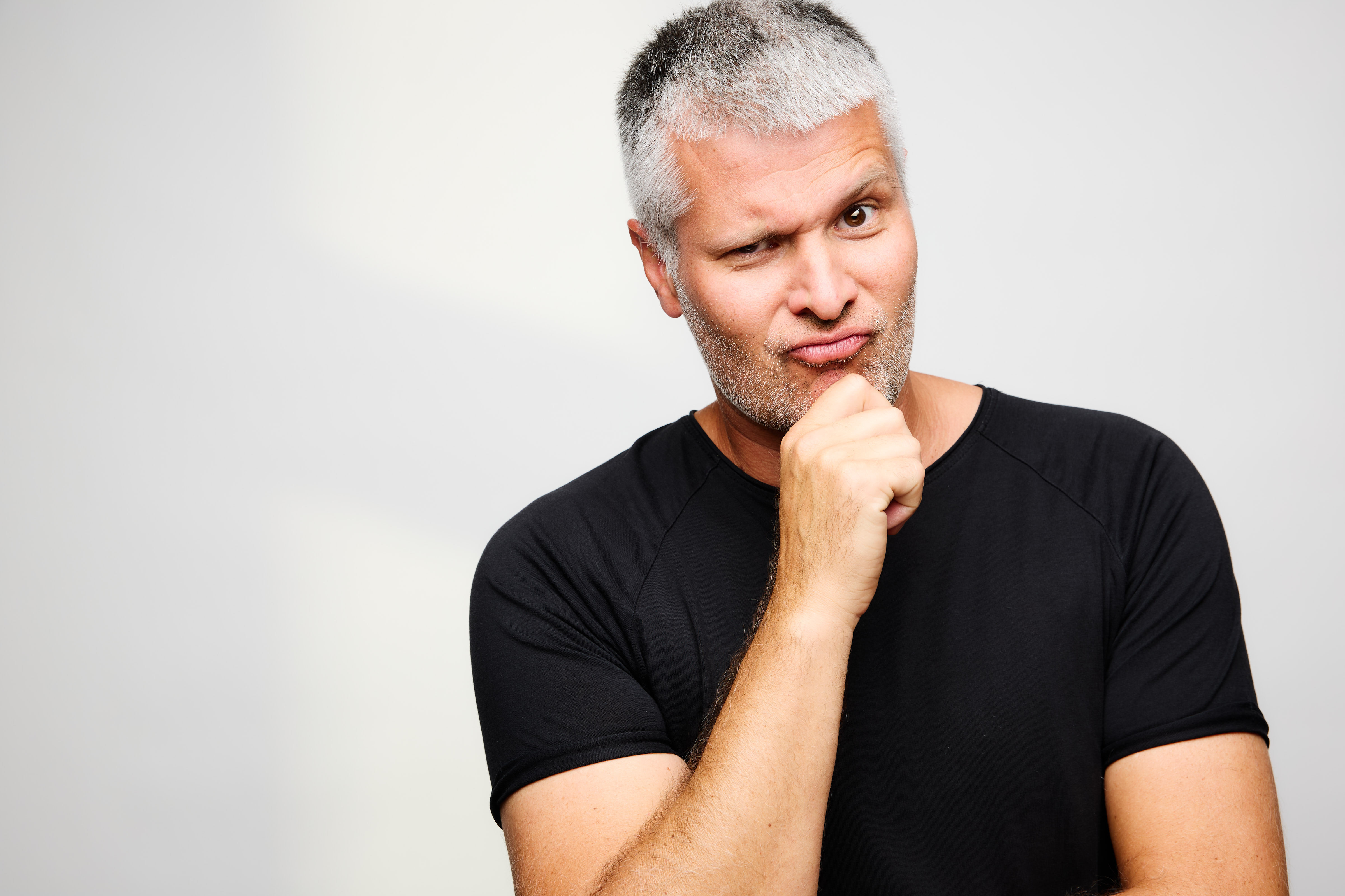 Portrait mit der Hand am Kinn vor hellem Hintergrund